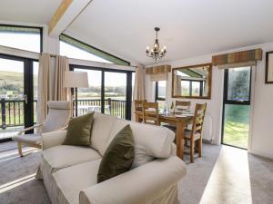 Manor Farm Lodge في ساليزبري: غرفة معيشة مع أريكة بيضاء وغرفة طعام