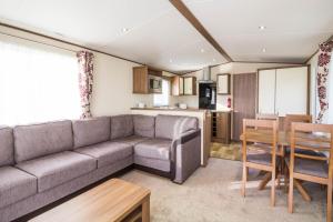 a living room with a couch and a table and a kitchen at Lovely 6 Berth Caravan At Carlton Meres Holiday Park In Suffolk Ref 60021r in Saxmundham