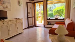 a living room with a couch and a television at Appartamento- La Casa del Mirto- Porto Rotondo in Porto Rotondo