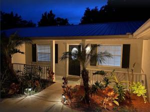 a house with a fence and palm trees in front of it at 3 bedroom 2 bath with hot tub, game room and boat slip in Crystal River