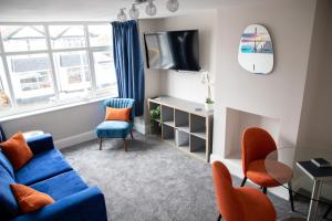 a living room with a blue couch and a window at Wave Stays - First Floor Apartment in Cleveleys