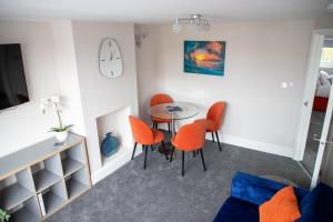 uma sala de jantar com cadeiras laranja e uma mesa em Wave Stays - First Floor Apartment em Cleveleys