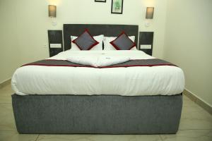a bedroom with a large bed with red pillows at Seasons Stay in Vijayawāda
