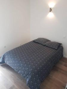 ein Bett in einem Schlafzimmer mit einer Lampe darüber in der Unterkunft Appartement T2 Saint Malo, Dinard, Dinan et Dol in Miniac-Morvan