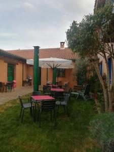 a group of tables and chairs in a yard at ALBERGUE peregrinos CASAFLOR in Murias de Rechivaldo