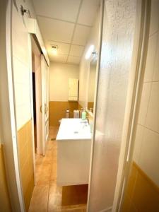 La salle de bains est pourvue d'un lavabo blanc et d'un miroir. dans l'établissement MyChoice Dadim by Bossh! Apartments, à Rota