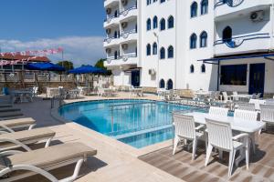 una piscina en un hotel con sillas y una mesa en Eroglu City Hotel, en Fethiye