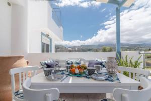 a white table with a bowl of fruit on a balcony at Minoas Apt Next to the Beach in Milatos