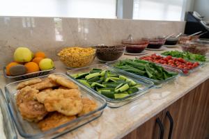 a counter topped with trays of different types of food at Eroglu City Hotel in Fethiye