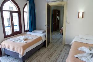 a bedroom with two beds with towels on them at Eroglu City Hotel in Fethiye