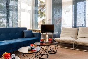 a living room with blue couches and tables at Hotel Villa Aurora in Crikvenica