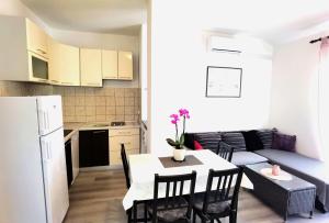 cocina y comedor con mesa y sillas en Apartments & Rooms Milena, en Vodice