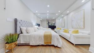 biała sypialnia z dużym łóżkiem i kanapą w obiekcie Family Modern walkout Basement wSauna Indoor Fireplace Wifi w mieście Innisfil