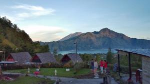 a group of people standing in front of a mountain at Bali Cottages Lake View in Kintamani