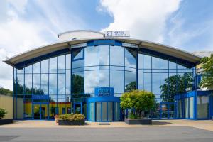 een groot glazen gebouw met een bord erop bij Hotel Strohofer in Geiselwind