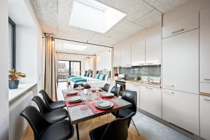 een keuken en eetkamer met een tafel en stoelen bij Lit Living - Luxus Loft - Box Spring - Air Con - BBQ - Panorama in Mannheim