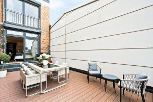 une terrasse avec des chaises et une table dans un bâtiment dans l'établissement Lit Living - Luxus Loft - Box Spring - Air Con - BBQ - Panorama, à Mannheim