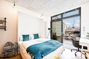 a bedroom with a bed and a desk and a window at Lit Living - Luxus Loft - Box Spring - Air Con - BBQ - Panorama in Mannheim