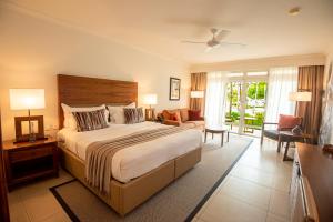 una camera da letto con un letto grande e un soggiorno di Sands Suites Resort & Spa a Flic-en-Flac