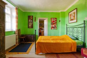 - une chambre avec des murs verts et un lit avec une couverture orange dans l'établissement Landhaus Hideaway Ruheoase Pool, à Pirching am Traubenberg