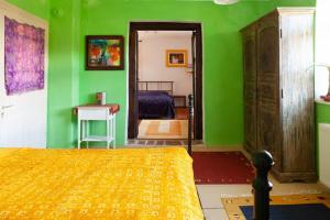 a bedroom with green walls and a bed with a yellow bedspread at Landhaus Hideaway Ruheoase Pool in Pirching am Traubenberg