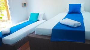 2 camas sentadas junto a una ventana en una habitación en Linda cabaña en Isla frente a Cartagena en Cartagena de Indias