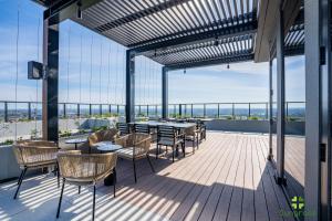 a patio with tables and chairs on a roof at Liberty One in Melbourne