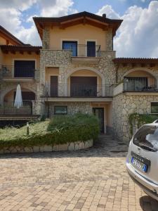 a house with a car parked in front of it at Tassido Coda Resort in Scanno