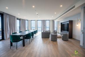 uma sala de conferências com uma mesa longa e cadeiras verdes em Liberty One em Melbourne