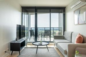 a living room with a couch and a tv and a table at Liberty One in Melbourne