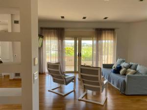 - un salon avec un canapé et deux chaises dans l'établissement Villa Olivetti, à Anavyssos
