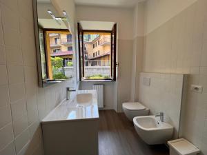 a bathroom with two sinks and a toilet and a mirror at Regolo House Apartments in Perledo +19 photos