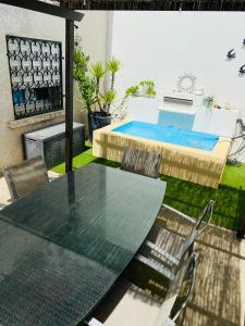 een patio met een tafel en stoelen en een zwembad bij Etape du soleil in Lunel