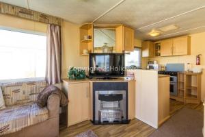 sala de estar con sofá y cocina en 8 Berth Caravan For Hire By The Beautiful Beach In Heacham, Norfolk Ref 21055a, en Heacham