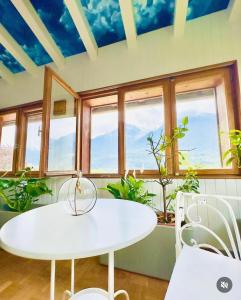 un tavolo bianco con sedie in una stanza con finestre di Quart de Lune - Boutique Stay ad Aosta