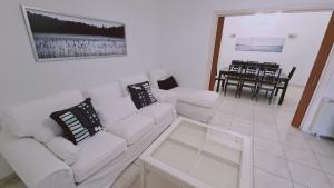 ein Wohnzimmer mit einem weißen Sofa und einem Tisch in der Unterkunft STAY Mythos Down Town House in Nikosia