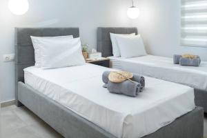 2 camas con sombreros y toallas en un dormitorio en Helios, en Ierápetra