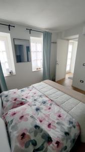 - une chambre dotée d'un lit avec un couvre-lit floral et des fenêtres dans l'établissement Stanza Allegra Soave, à Soave