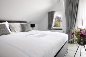 1 dormitorio con 1 cama blanca grande y un jarrón de flores en Vila Mignon, en Bled