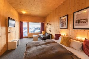 ein Schlafzimmer mit einem Bett und einem Sofa in einem Zimmer in der Unterkunft Venet Gipfelhotel in Zams