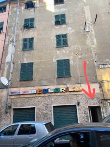 ein Gebäude mit grünen Rollläden und einem Schild darauf in der Unterkunft una stanza in un appartamento in Genua
