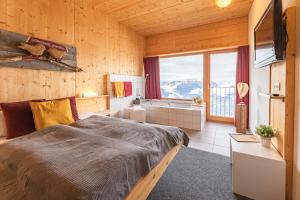 ein Schlafzimmer mit einem Bett und einem großen Fenster in der Unterkunft Venet Gipfelhotel in Zams