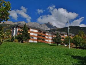 a large building with mountains in the background at Tgesa Sunnmatt Nr 46 in Savognin