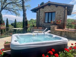 a hot tub in front of a house at Agriturismo Il Colle in Poggio Alla Croce