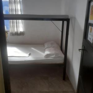 ein kleines Bett in einem Zimmer neben einem Fenster in der Unterkunft hostel Sereia do itapua in Salvador