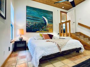 a bedroom with a bed and a painting on the wall at Jania Boho Chic Retreat in Austin