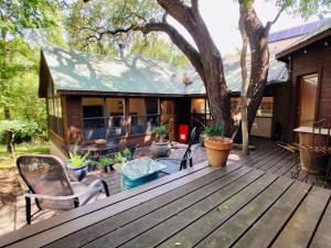 a wooden deck with plants and a house at Jania Boho Chic Retreat in Austin