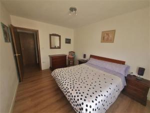 a bedroom with a bed with a black and white comforter at Excelente apartamento en el Pirineo aragonés in Sabiñánigo