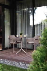uma mesa e duas cadeiras num pátio em Parko Aveniu Apartamentai em Birstonas