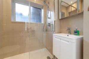a bathroom with a glass shower and a sink at Bright Studio Flat in the Heart of Marylebone in London